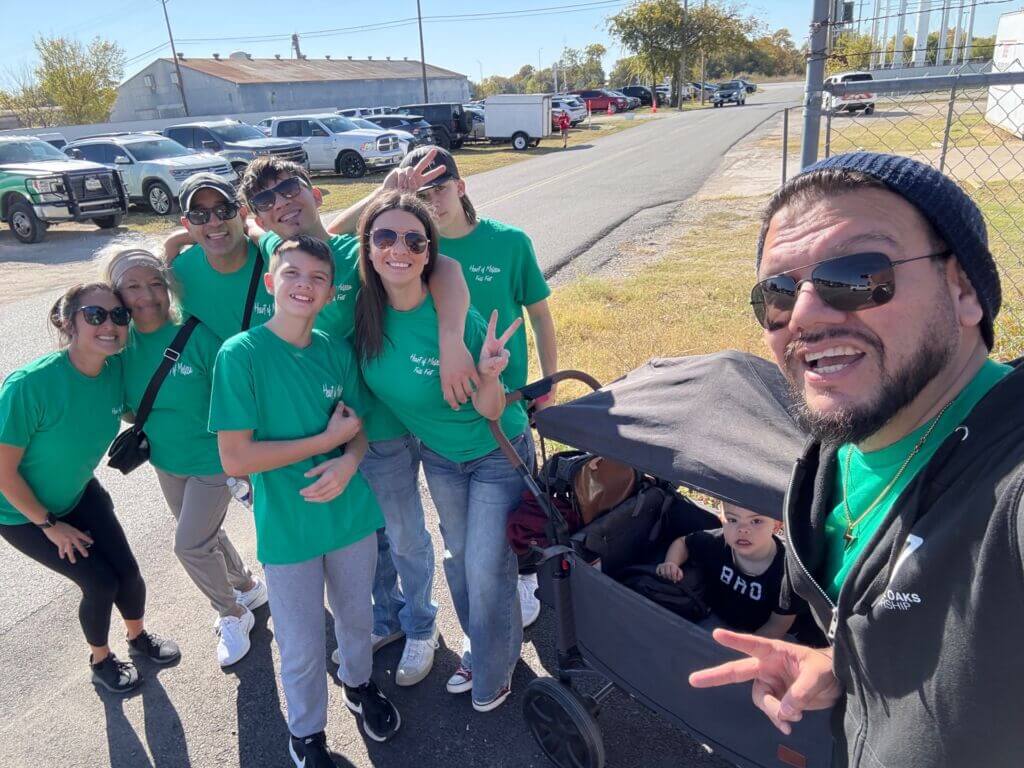 People in green shirts smiling for a photo