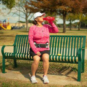 Woman drinking water ona park bench