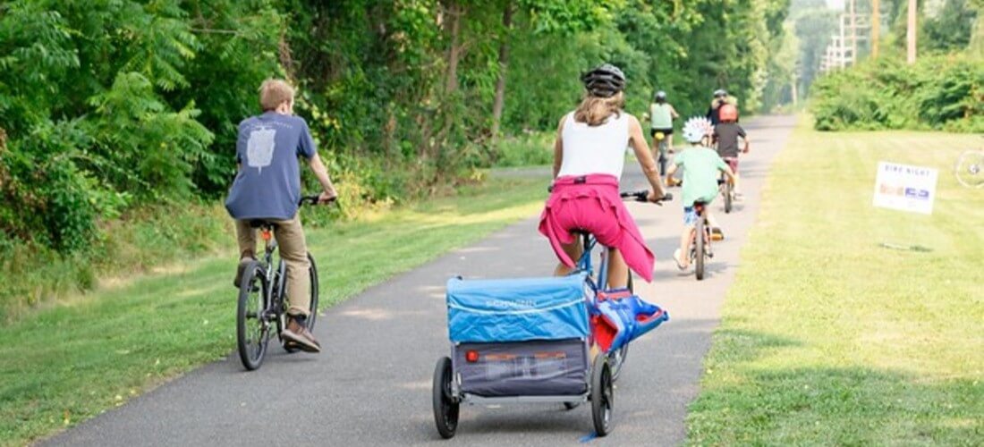 Adults and children riding bikes on the rail trail