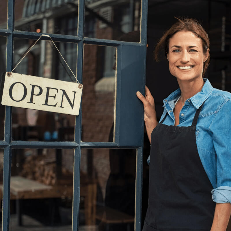 Women with Open Sign in front of small business