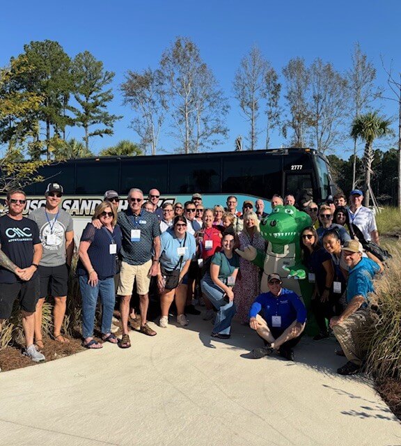 Attendees pose in front of tour bus at the CARVC Fall Crawl Tour