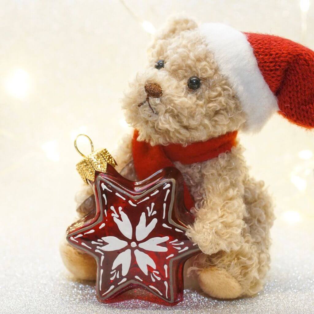 stuffed bear holding an ornament