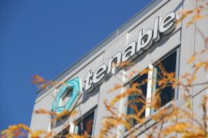 A closeup on the Tenable logo as it appears at the top of their office building's facade in Columbia, Maryland on a sunny fall day.