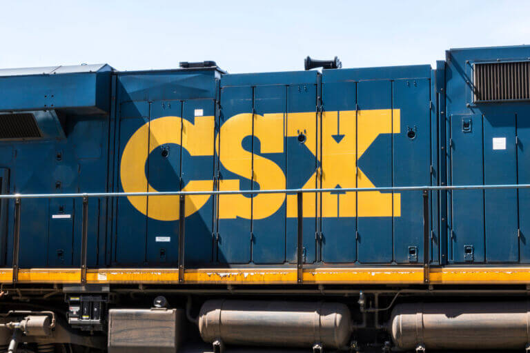 A close up of a blue CSX Train Car with yellow letters spelling out C-S-X.