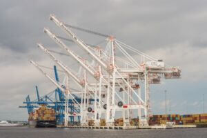 The Port of Baltimore as seen during the day with cranes, shipping containers and vessels.