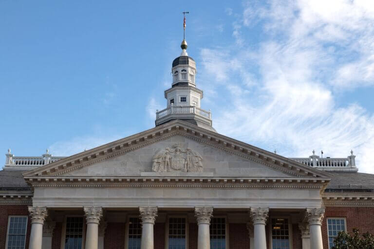 Maryland State House building's west facade in Annapolis on a partly cloudy day.