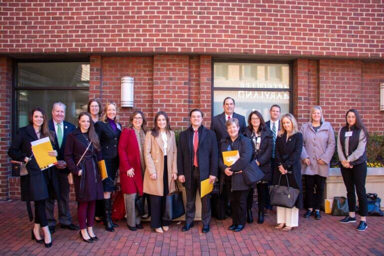 Members of the Maryland Chamber of Commerce Federation and organization staff posing in front of a brick building.