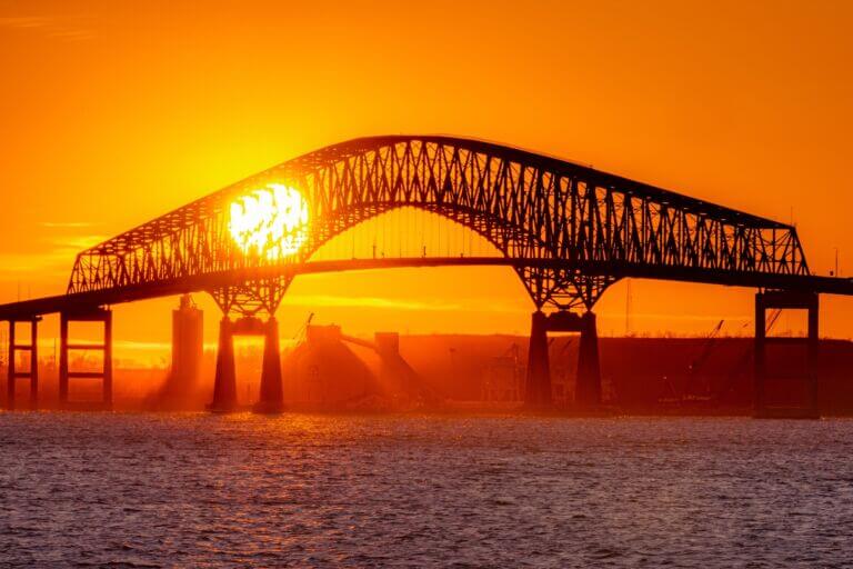 Sun setting behind former Key Bridge in Baltimore, Maryland