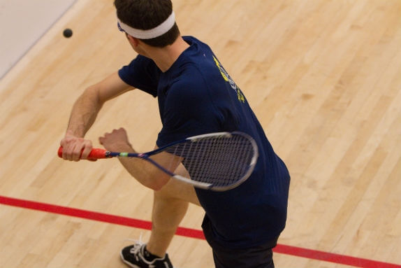 man playing squash indoor court