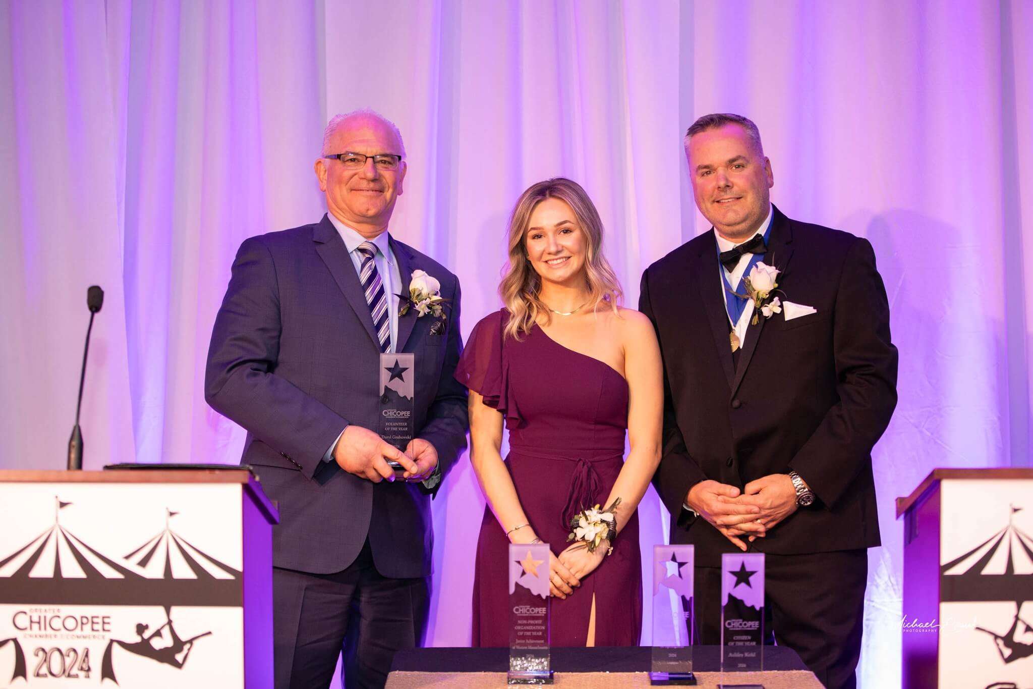 Daryl Grabowski accepting the Volunteer of the Year Award, of the Year award, with Emcees Jeremy Procon and Haley Procon.