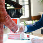 Outlook Handshake Author Henry Grabar Shakes Hands Over a Table