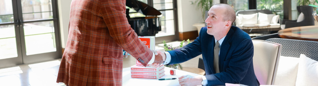 Author Henry Grabar Shakes Hands Over a Table