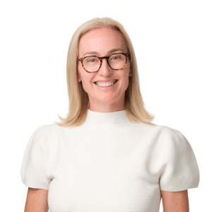 A blonde woman wearing glasses and a white shirt