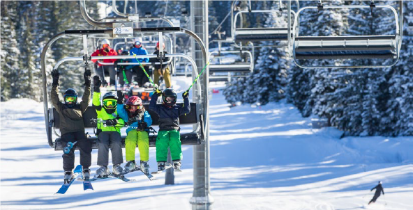downhill skiers on ski lift