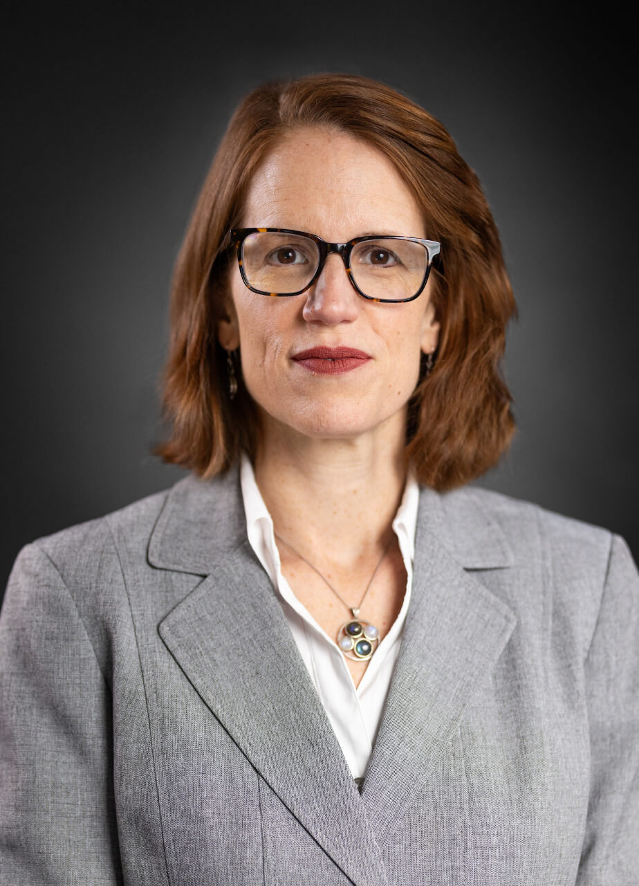 Searing Headshot_small Dr. Elizabeth Searing headshot. She is wearing a gray blazer and white button down shirt.