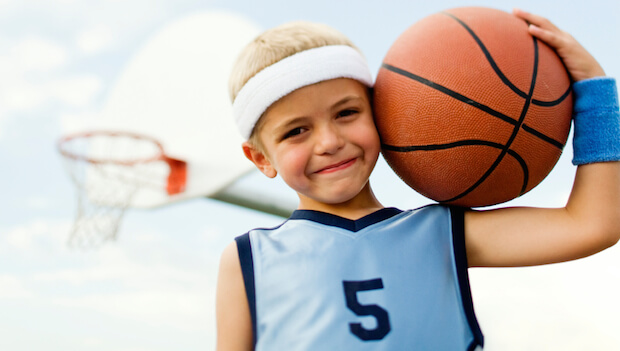 boy in basketball uniform with basketball