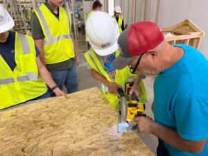 instructor helps carpentry students