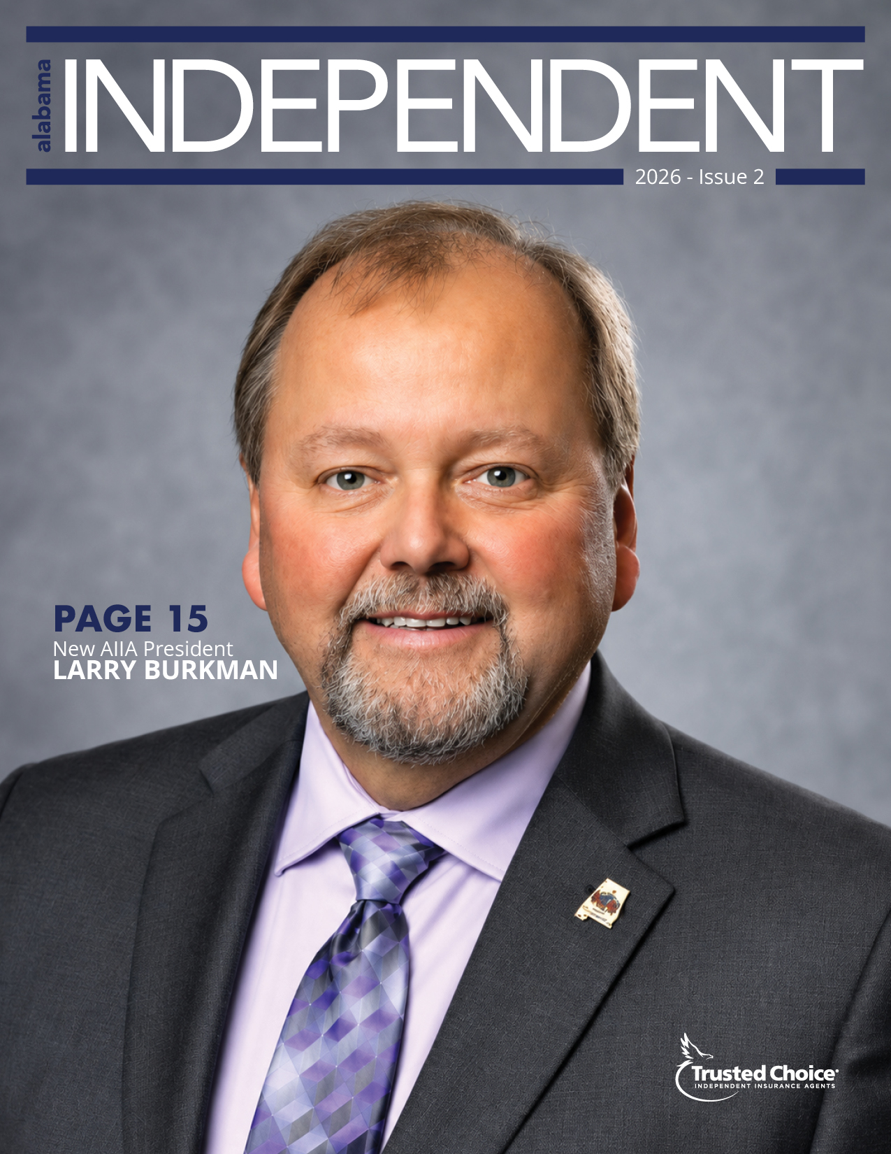 smiling man in a business suit. man has a gray and blonde goatee