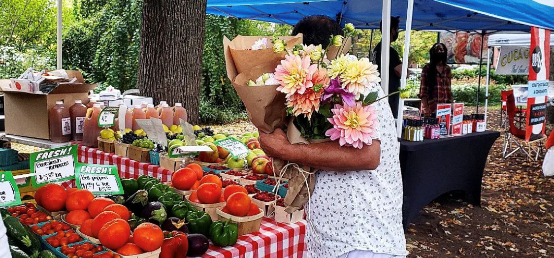person holding flowers and looking at produce