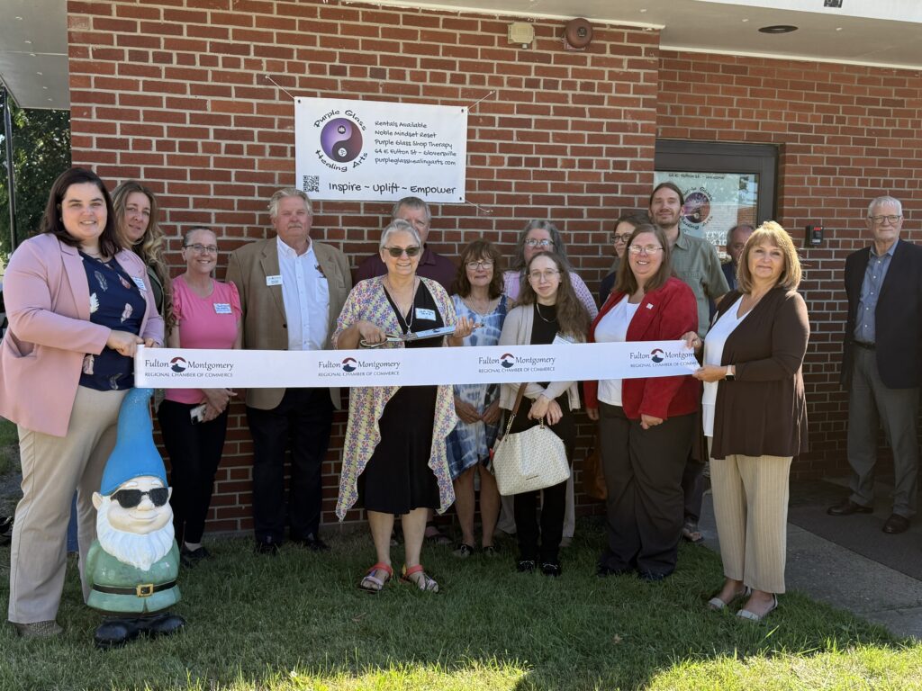 ribbonCuttingPurpleGlass Image of the Chamber of Commerce and Purple Glass Healing Arts staff holding up a ribbon to cut for joining the chamber of commerce