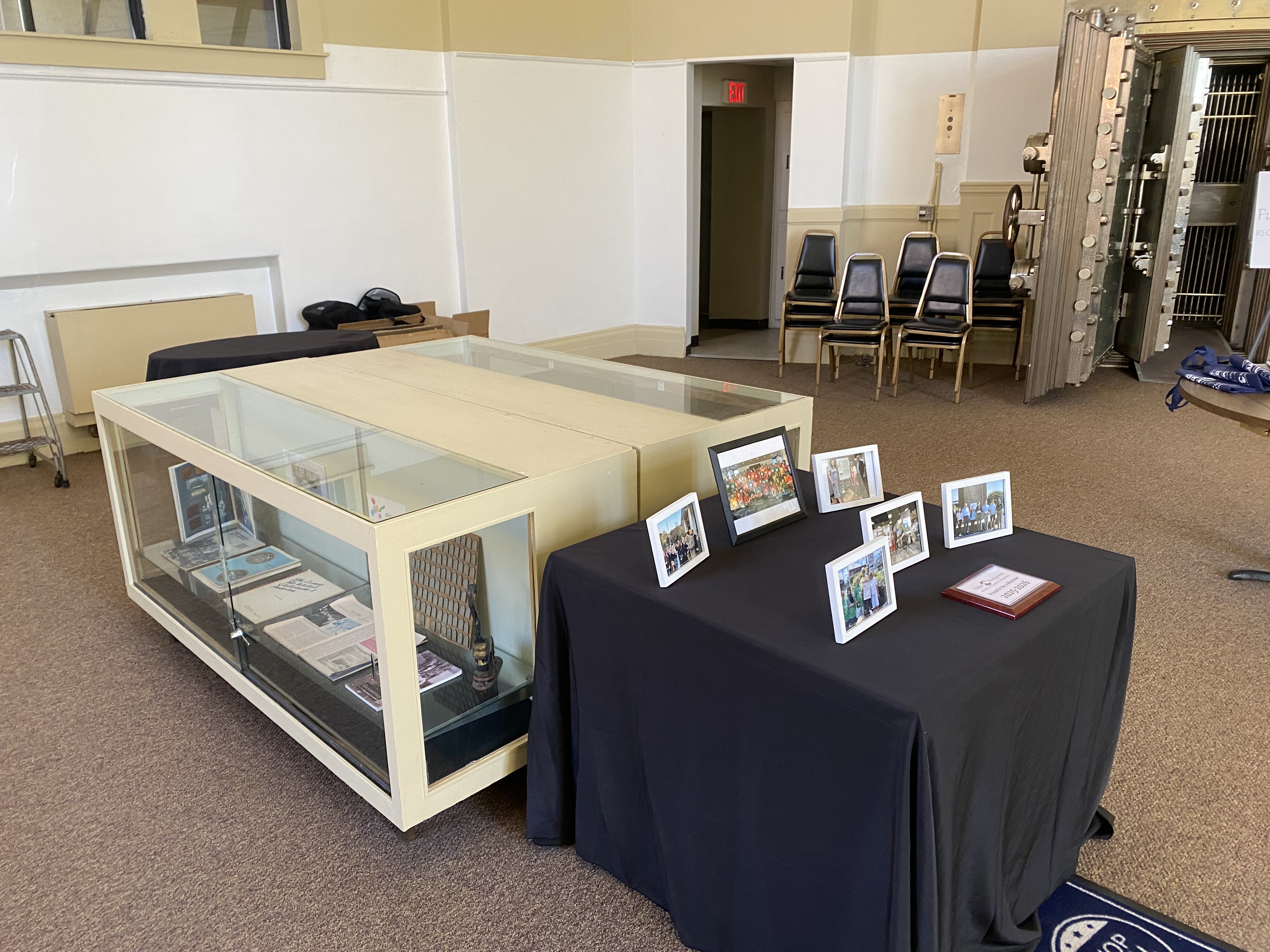 chamberGalleryDisplayCaseOct2025 Image of a display case inside the main lobby to the chamber of commerce along with a table with member group photos on it