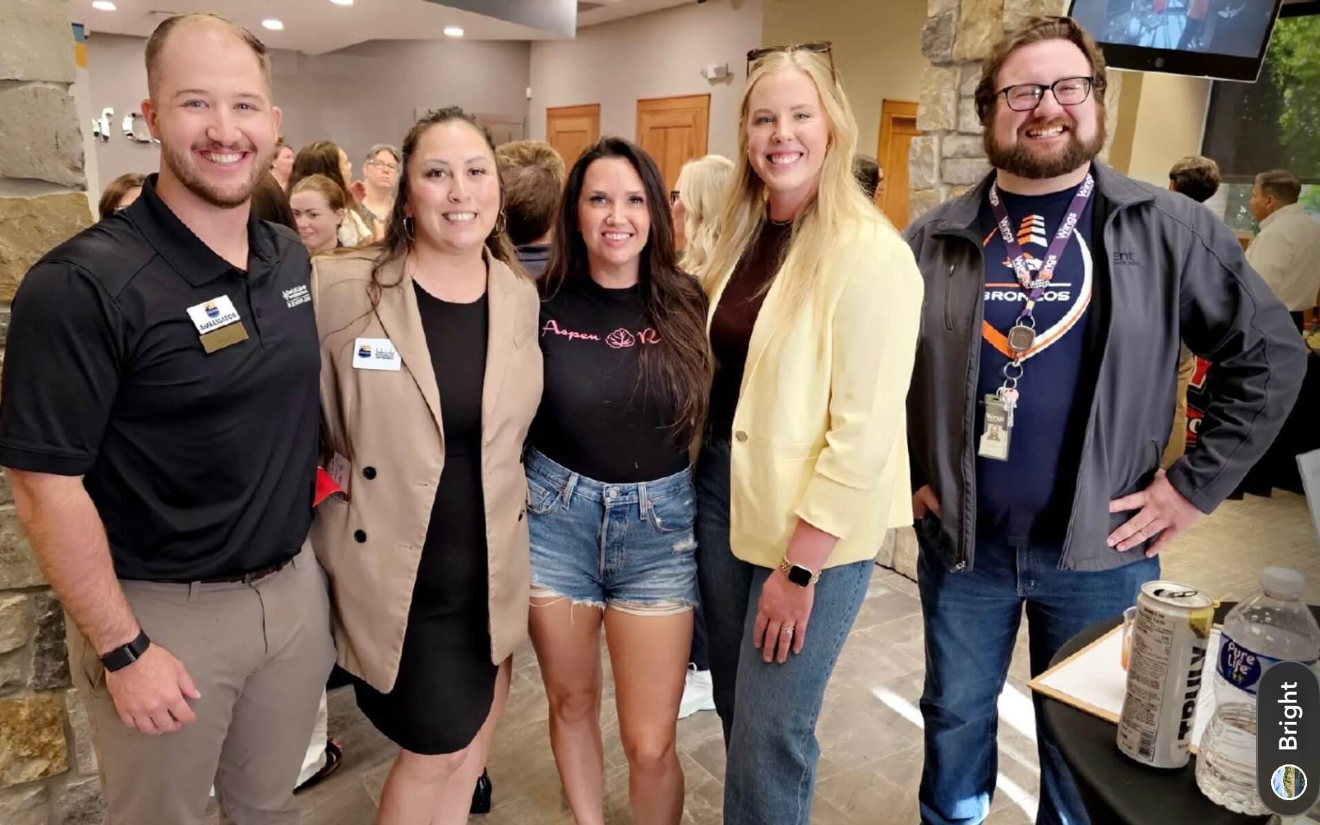 Group of you people standing next to one another smiling.