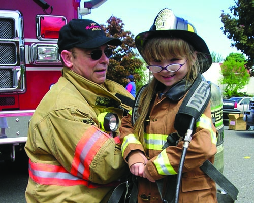 firefighter in gear with child wearing firemans hat