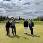 People standing at a golf hole