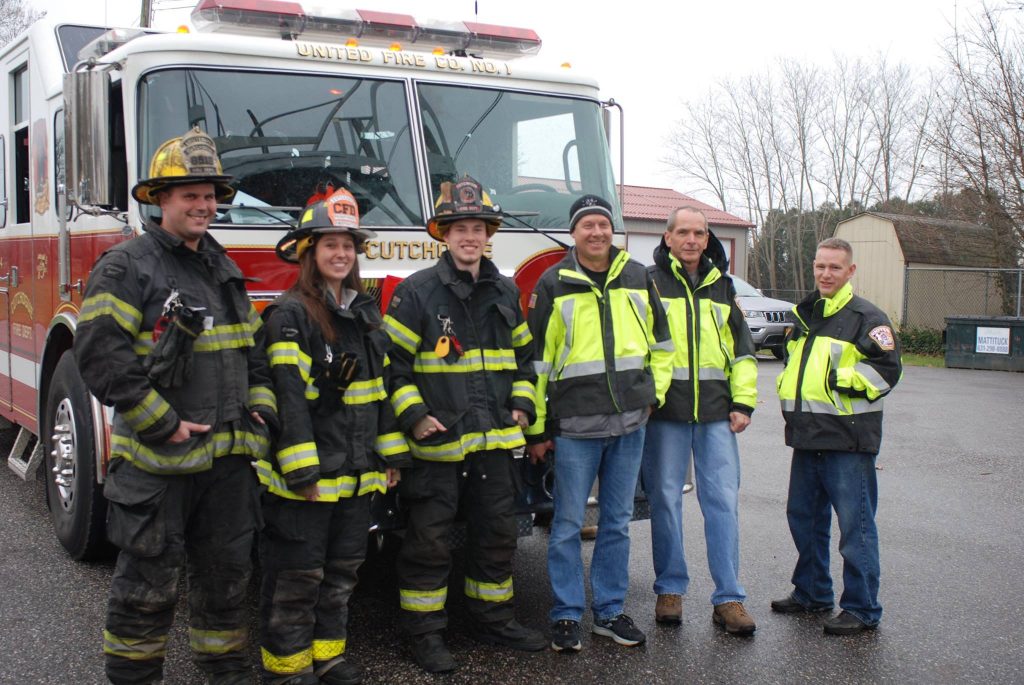 group of firefighters standing in front of fire truck