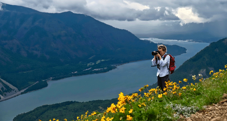 Photographer shooting the landscape with mountains in the distance