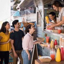 people conversing outside of a food truck