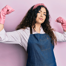 woman flexing biceps in work gear and rubber gloves
