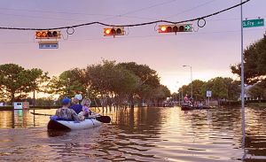 people in a kayak on a flooded street