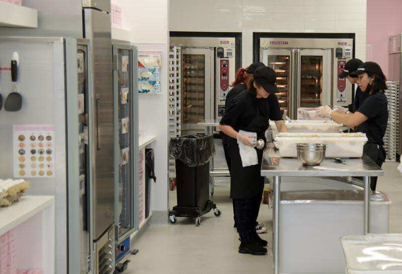 Workers in the kitchen at Crumbl Cookies in South Elgin