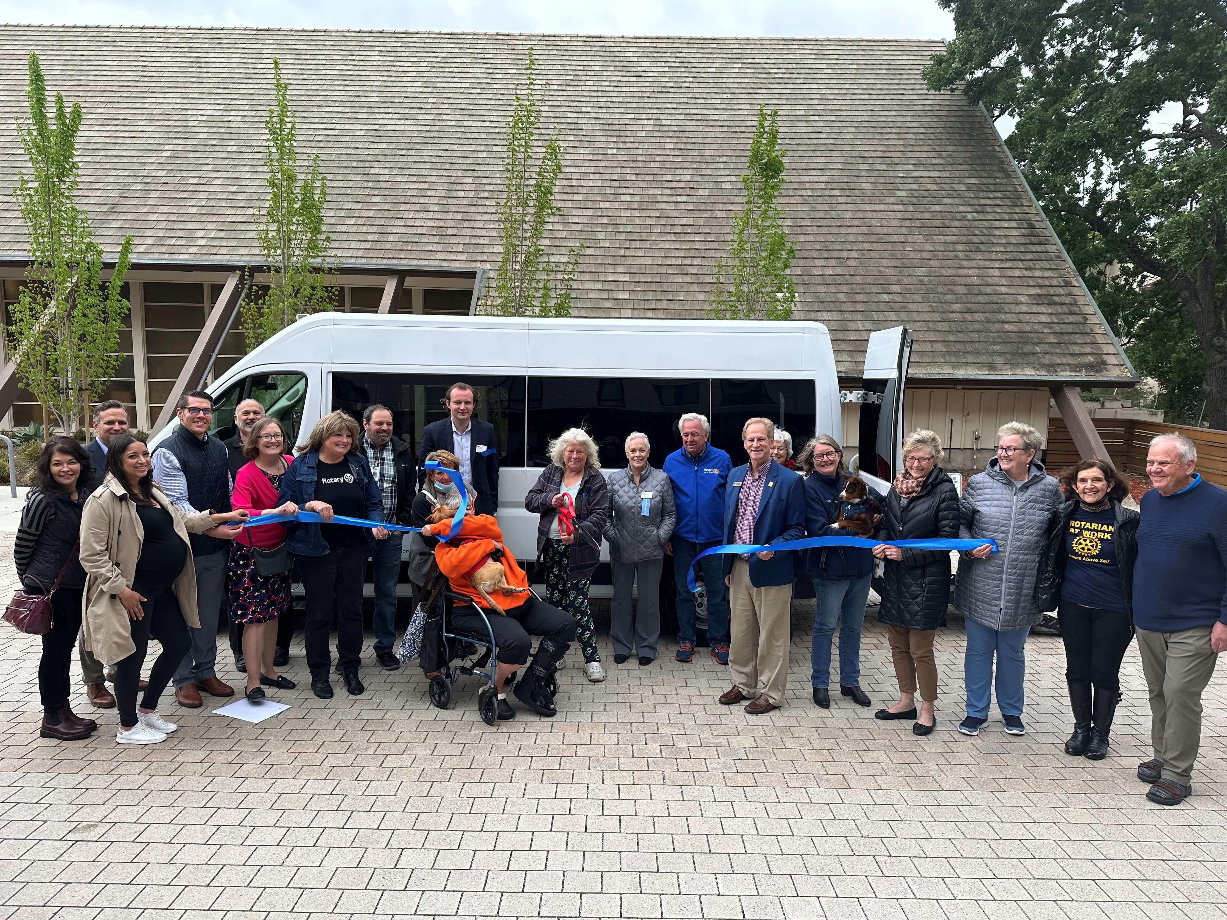 Group celebrating the new van for the Trinity Center with a ribbon cutting