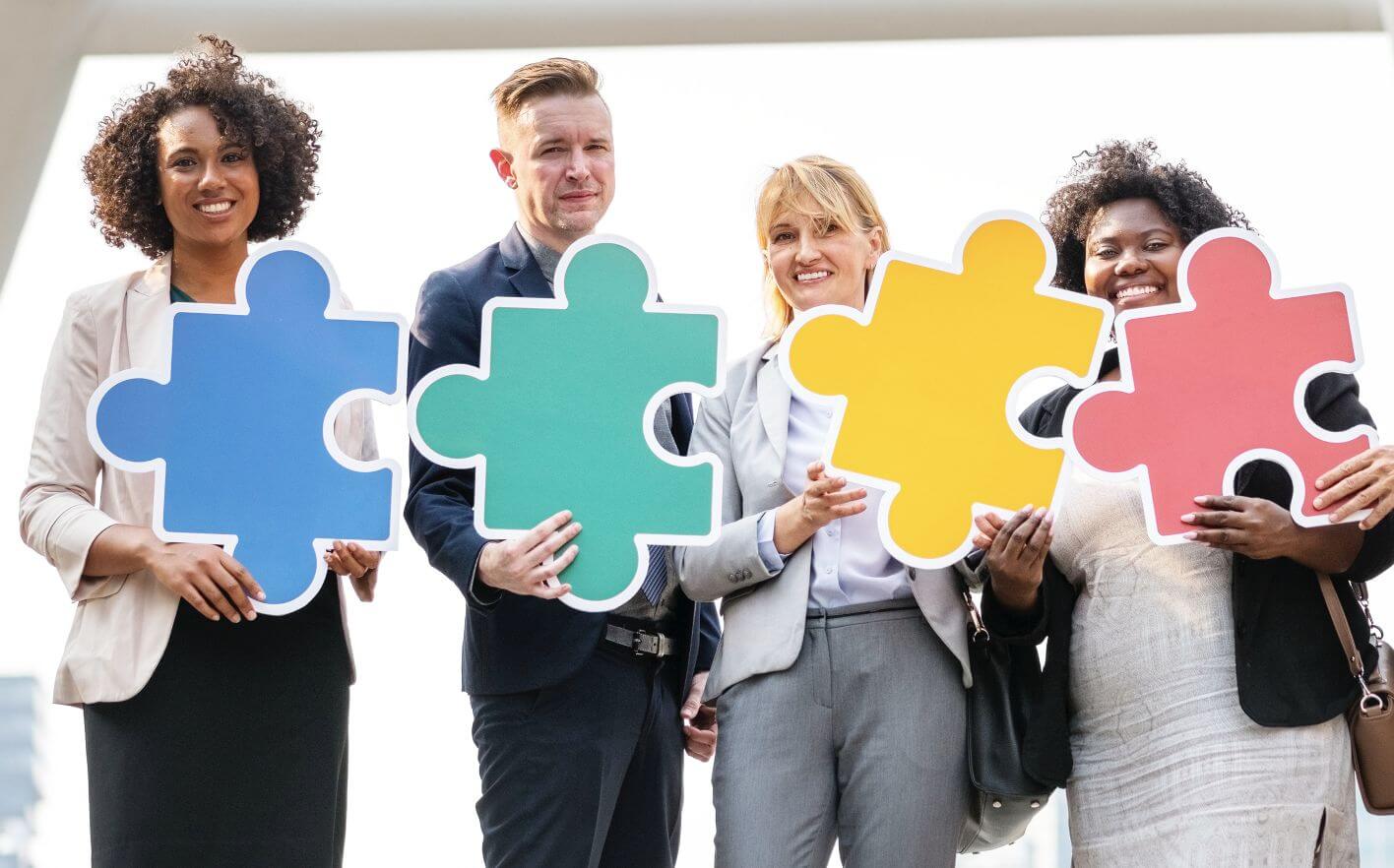 Photo of business people holding interlocking puzzle pieces