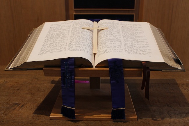 Leadership-Preaching - Bible open on a stand with a cross in the middle of the bible