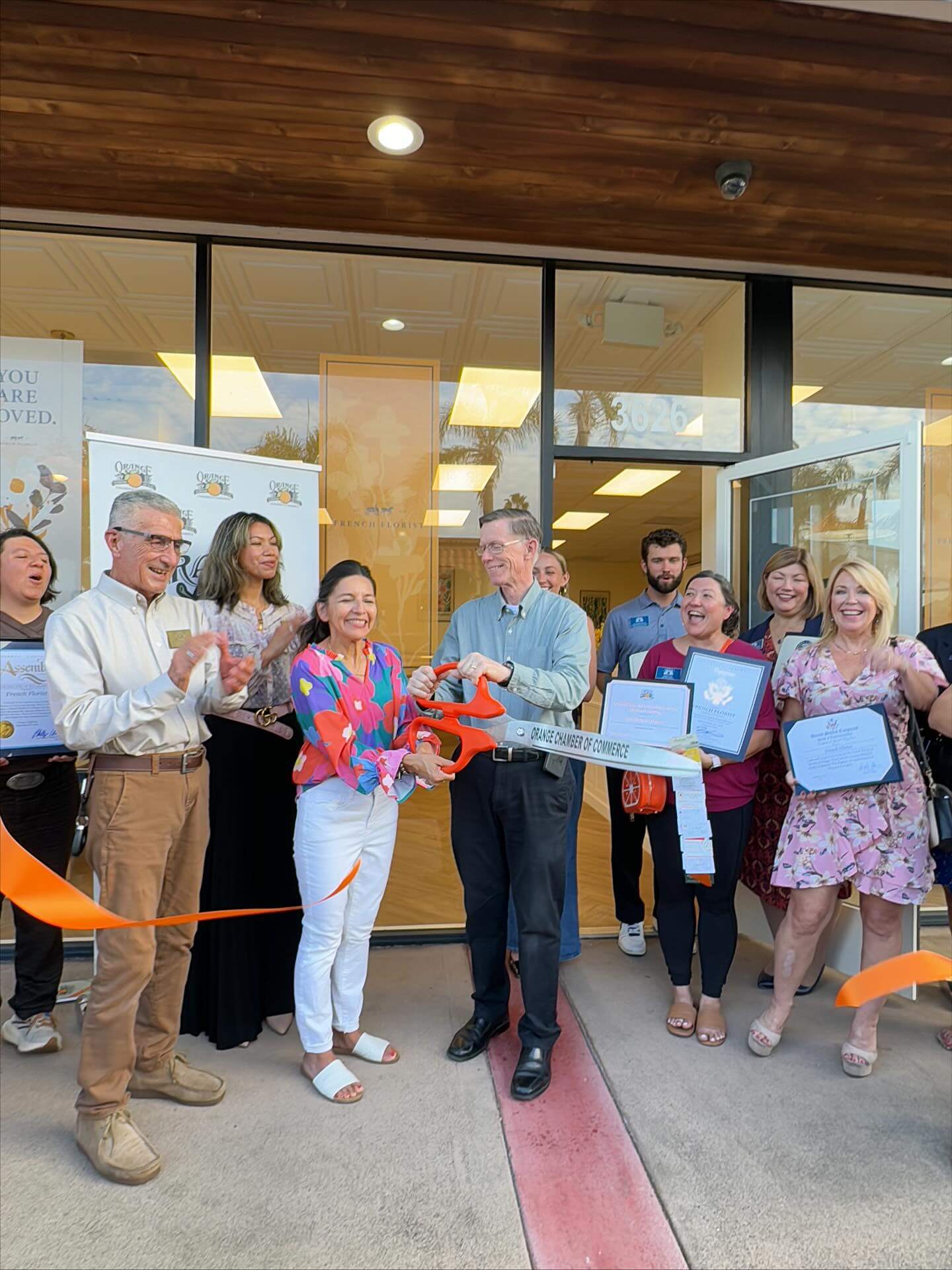 French Florist ribbon cutting in orange