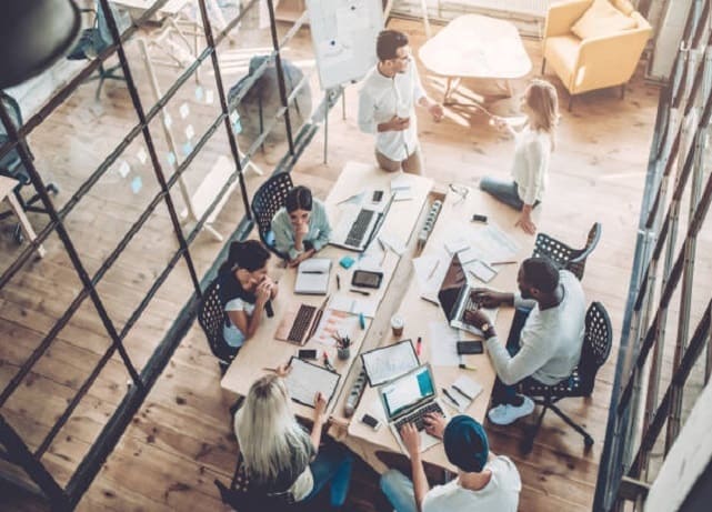 People working on computers around conference table