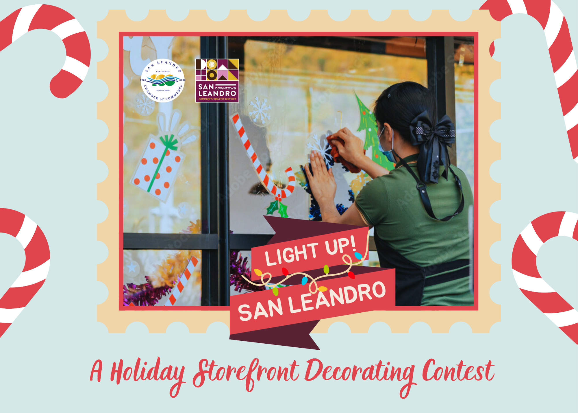 Photo of a person setting up festive lights on a window for Light Up San Leandro.