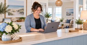 Innkeeper smiles as she works on her laptop at the reception desk