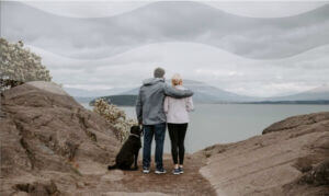 couple with dog looking at lake