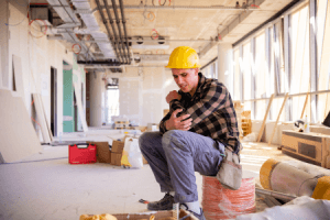 man sitting wearing a construction hat