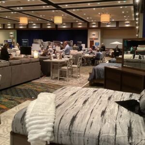 Photo from Midwest Furniture Show showing bedding display and people in the background