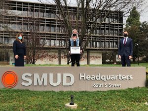 SMUD Feb 2021 Business of the Month photo in front of the SMUD sign with Rachelle Herendeen, Jim Alves and Susanne Dizon