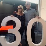 Photo of Terry Carson, owner of Carson's Coatings standing with her 25 year employe, Bobby Williams next to a large "30" sign (made by Carson's Coatings) for their 30th year in business - June 24 2021