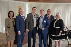 Alabama Lieutenant Governor, Will Ainsworth, Jason Isbell with Regions Financial Corporation, BCA President and CEO, Helena Duncan, and CCAA President and CEO, Paige Hutto presents representatives from Lawrence Paint &amp; Hardware with the Small Business of the Year Award.
