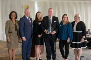 Alabama Lieutenant Governor, Will Ainsworth, BCA President and CEO, Helena Duncan, and CCAA President and CEO, Paige Hutto presents representatives from Wiregrass Electric Cooperative with the Small Business of the Year Award.