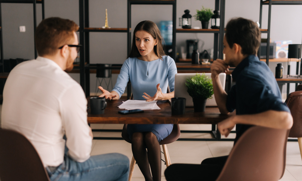 Realtor at table meeting with clients