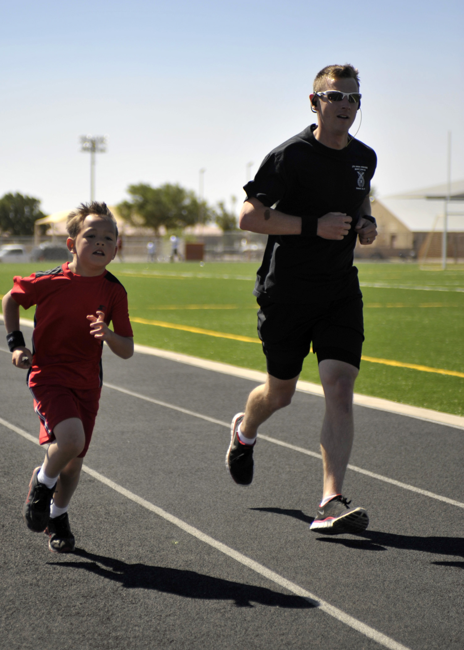 U.S. Air Force Tech. Sgt. Robert Wilson, 27th Special Operations Security Forces Squadron, and son Tyler , 7, sprint to the finish of the two mile race during the Americas Kids Run, at Cannon Air Force Base, N.M. May 21, 2011. Sergeant Wilson and Tyler were two of roughly 70 parents and children that competed in the mornings events. (U.S. Air Force photo by Airman Ericka Engblom)